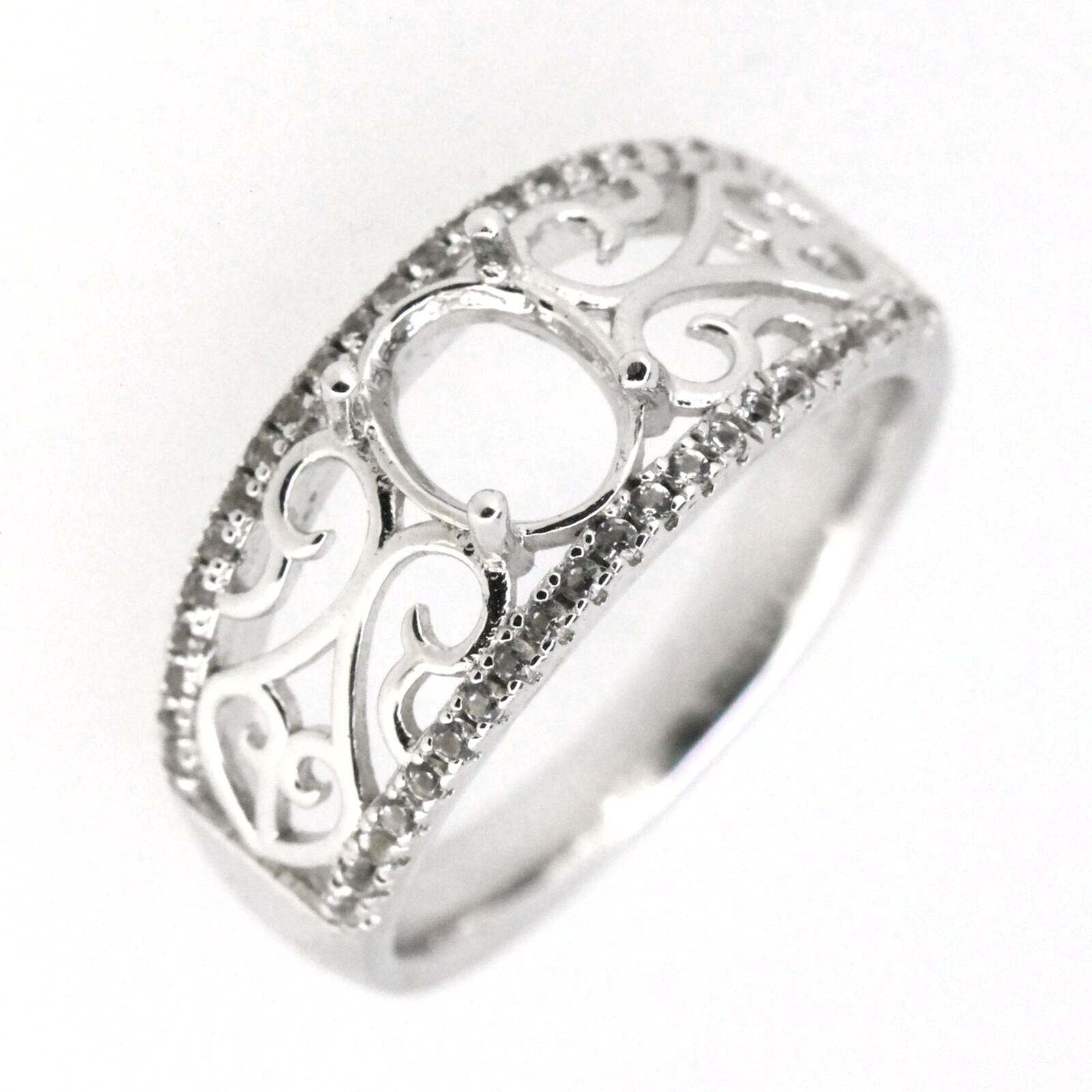 Sterling silver semi mount ring setting with filigree design, featuring an oval center and topaz accents.